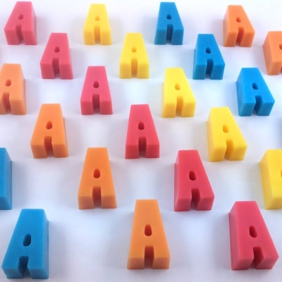 Peças tridimensionais coloridas em forma da letra A sobre fundo branco