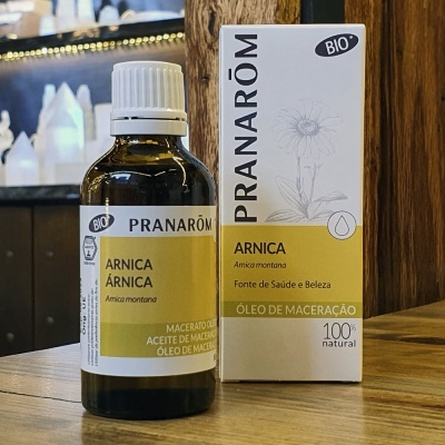 Frasco de óleo de maceração de Arnica da marca Pranarôm com embalagem ao lado