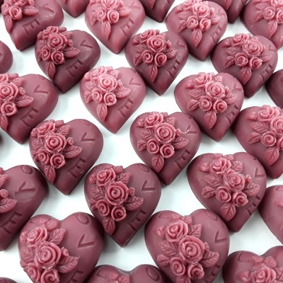 Chocolates em forma de coração cor de rosa com decoração floral