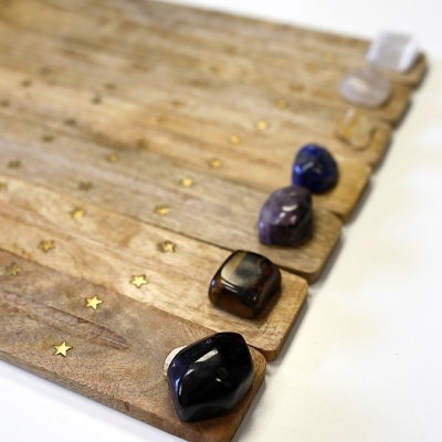 Pedras polidas coloridas em pranchas de madeira com estrelas douradas