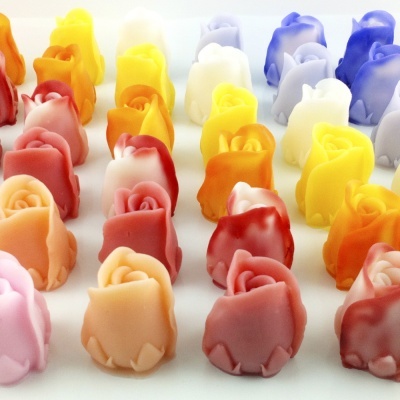 Velas pequenas em forma de rosa de várias cores alinhadas