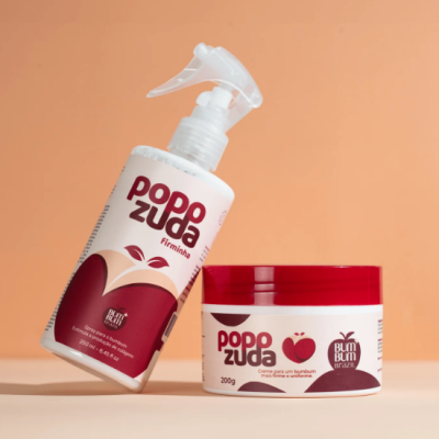 Dois produtos cosméticos Popozuda, um frasco pump e um pote, com detalhes vermelhos, sobre superfície clara e fundo laranja.