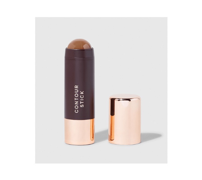 Bastão de contorno de maquilhagem preto e dourado com tampa removida num fundo cinzento claro