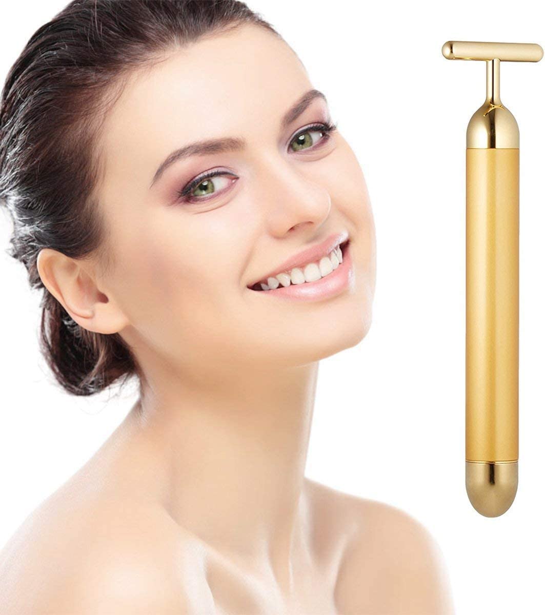 Mulher sorridente com massageador facial dourado em fundo branco