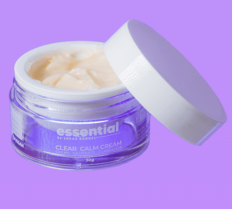Frasco aberto de creme facial Essential Clear Calm Cream com tampa branca sobre fundo lilás.