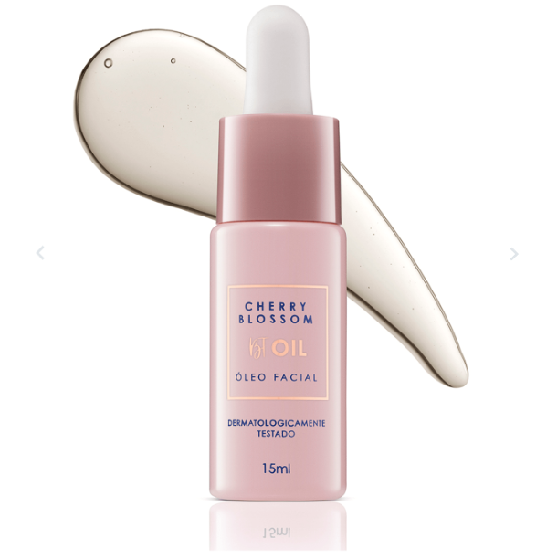 Frasco rosa de óleo facial Cherry Blossom com conta-gotas e mancha de óleo ao lado