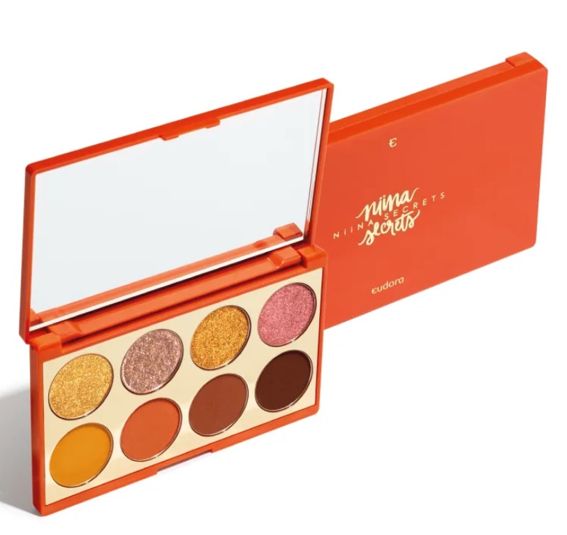 Paleta laranja de sombras com espelho e várias cores, incluindo dourado e castanho.
