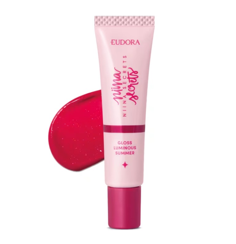 Tubo de gloss labial rosa claro com tampa rosa escuro e escrita vermelha, mancha de gloss vermelho atrás