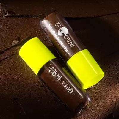 Dois batons castanhos com tampas amarelas em superfície castanha texturizada