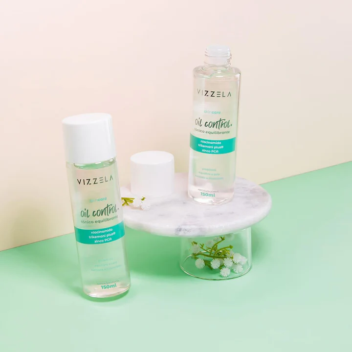Dois frascos de loção equilibrante VIZZELA oil control em base de mármore e vidro com fundo rosa e verde