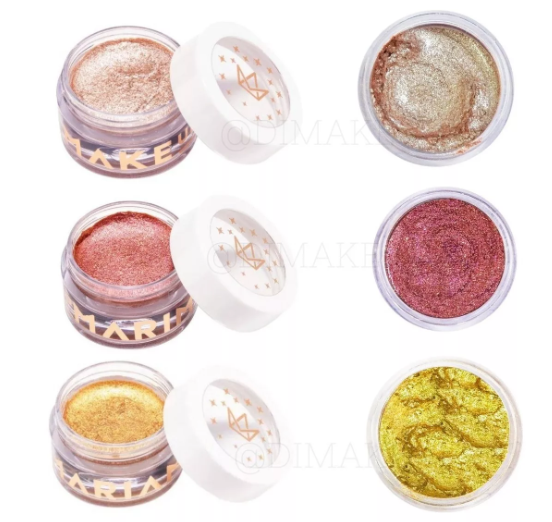 Três maquilhagens em potes com tampas brancas e texto dourado em fundo branco