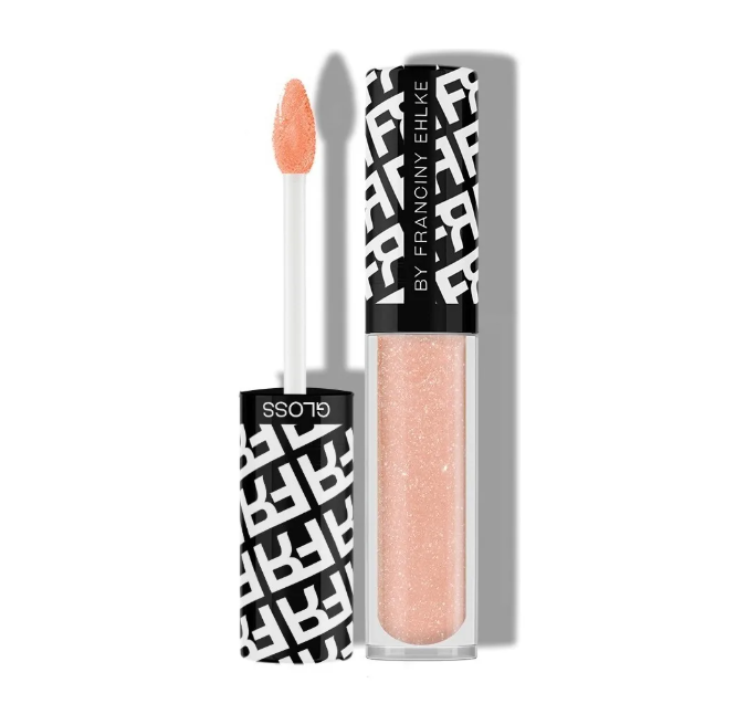 Gloss labial cor pêssego com embalagem preta e transparente e tampa com padrão de letras brancas.