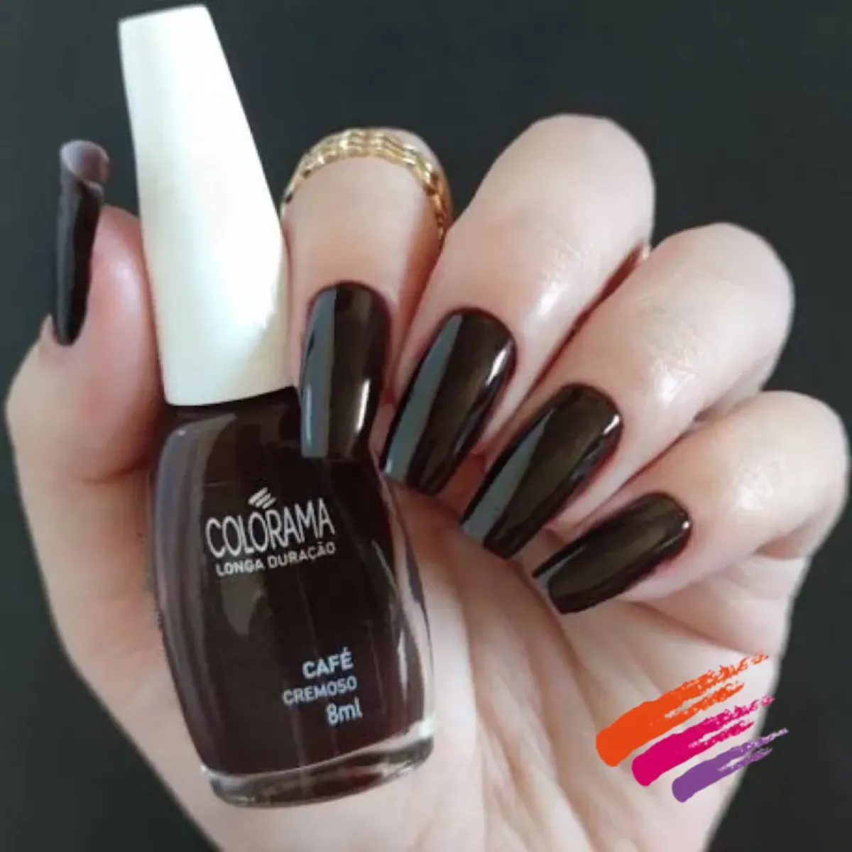 Mão com unhas pintadas de verniz castanho escuro e frasco de verniz Colorama Café Cremoso