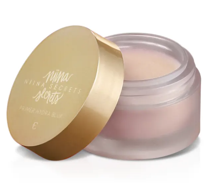 Frasco de creme transparente com tampa dourada e texto NIINA SECRETS