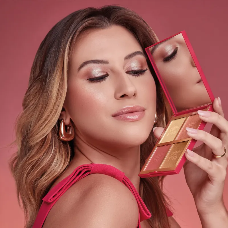 Mulher loira segura paleta de maquilhagem vermelha com espelho e quatro tons de pó