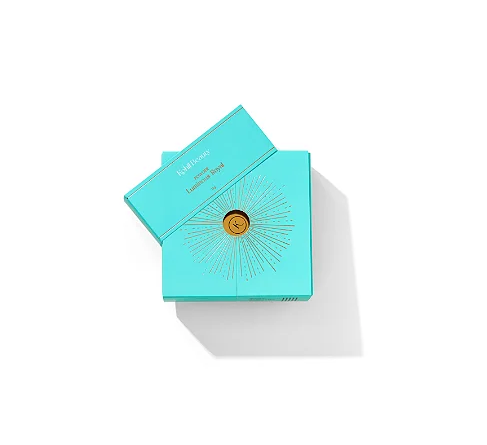 Caixa azul-turquesa de pó iluminador Kjaer Weis com decoração dourada