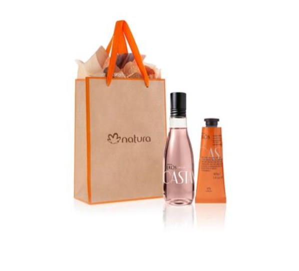 Conjunto com saco de papel kraft laranja, garrafa rosa e tubo de creme laranja