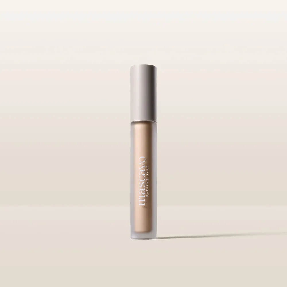 Tubo de maquilhagem líquida bege com tampa prateada e texto branco