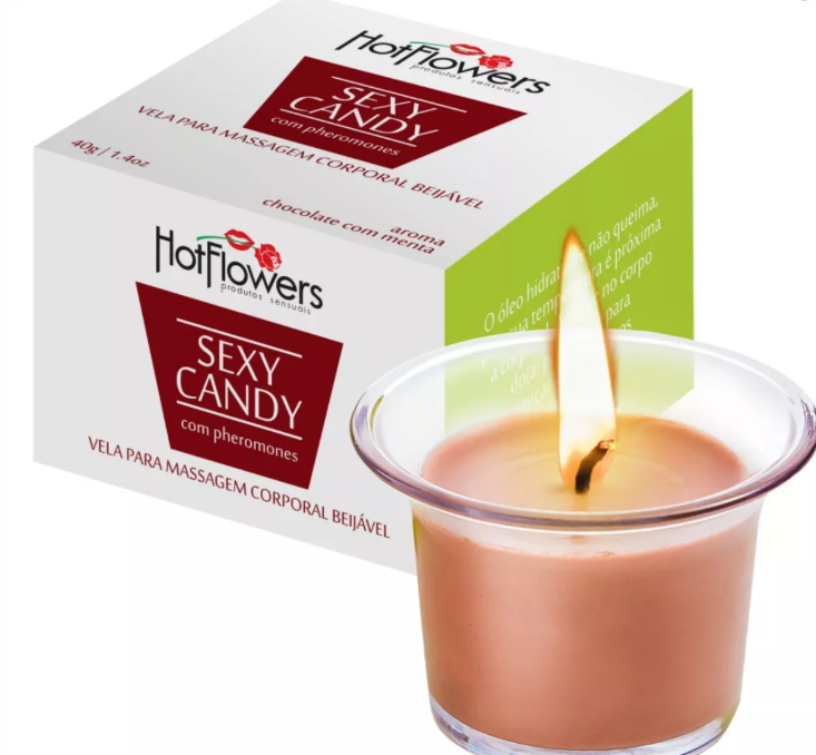 Vela de massagem corporal beijável Sexy Candy acesa ao lado da embalagem