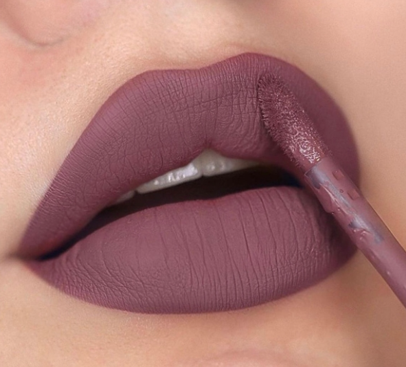 Lábios com batom líquido mate rosa antigo sendo aplicado