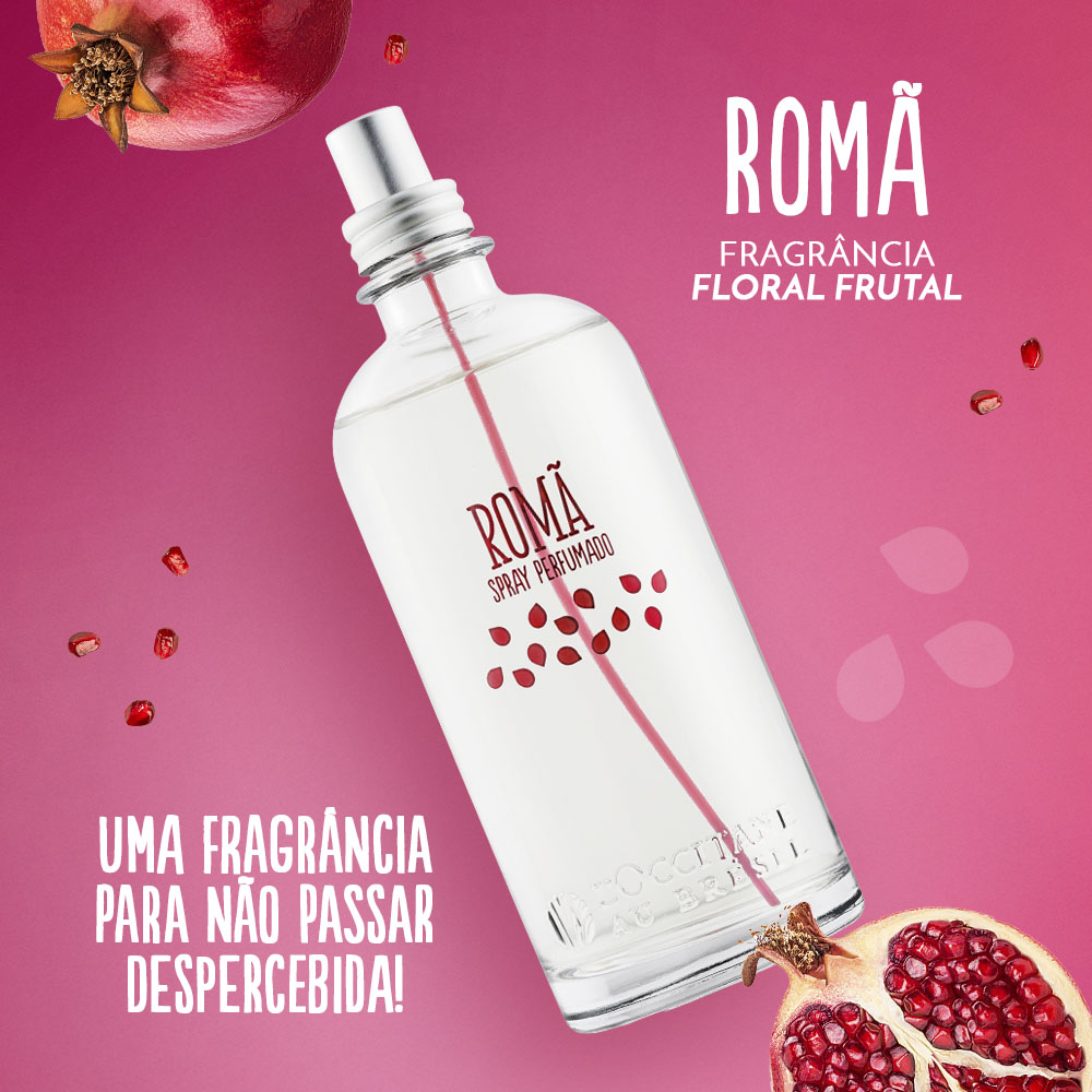 Frasco de spray perfumado ROMÃ com romãs ao fundo em cenário rosa