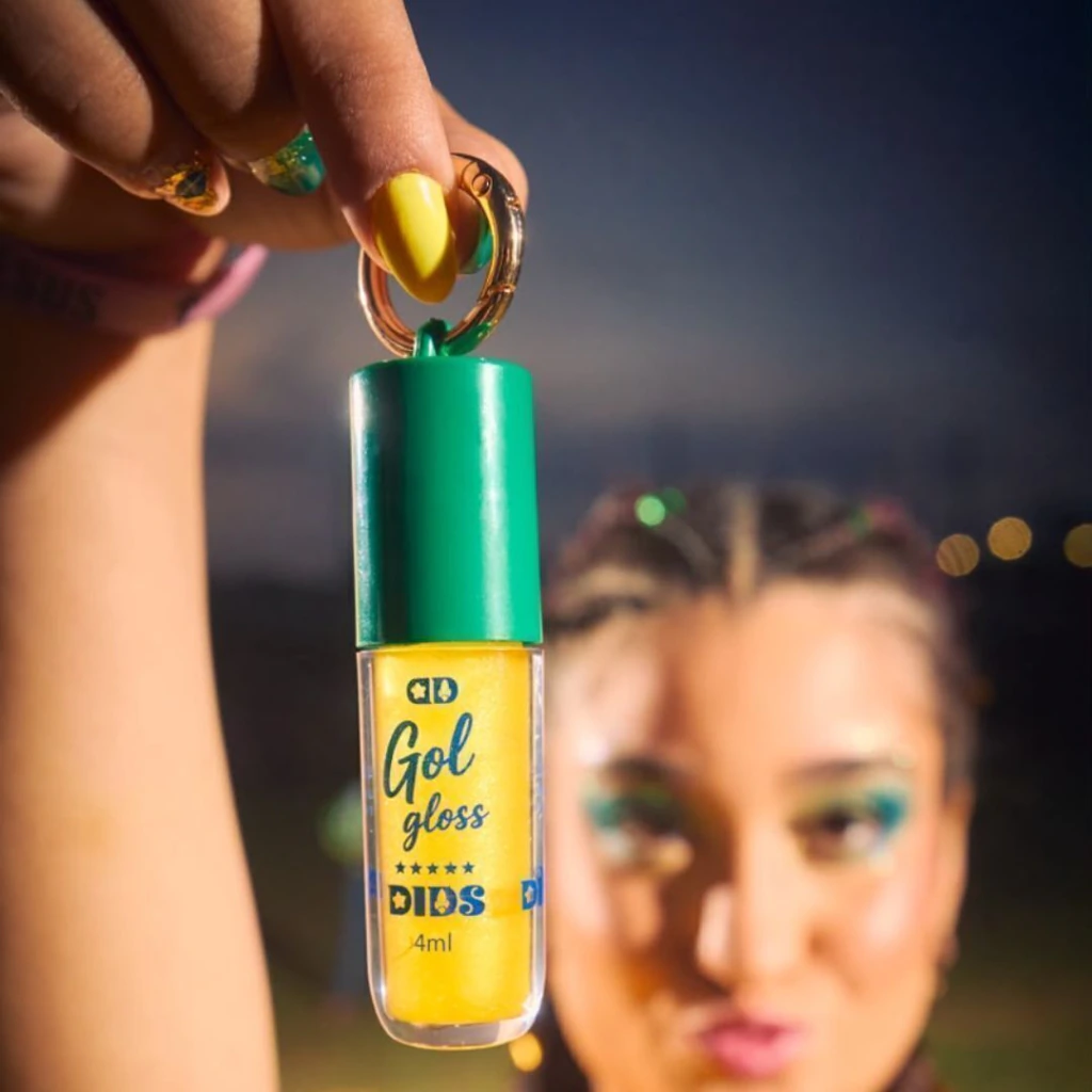 Frasco de gloss labial amarelo com tampa verde e argola dourada