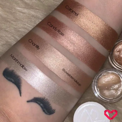 Swatches de quatro sombras líquidas brilhantes no braço com tatuagem de cílios, de cores Caramel, Candy Rose, Chantilly e Marshmallow.