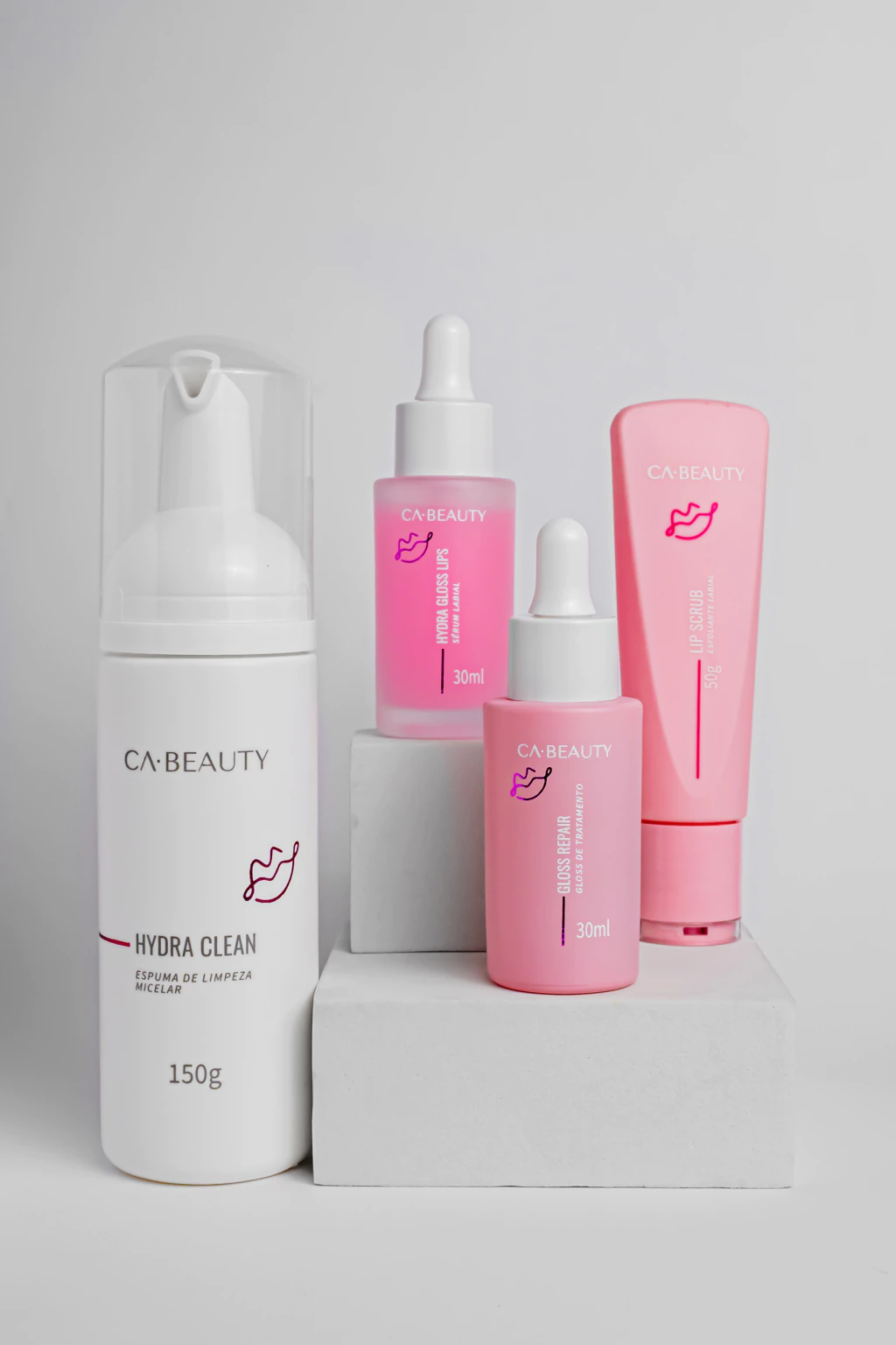 Produtos de cuidado labial CA·BEAUTY com embalagens brancas e rosas em fundo branco