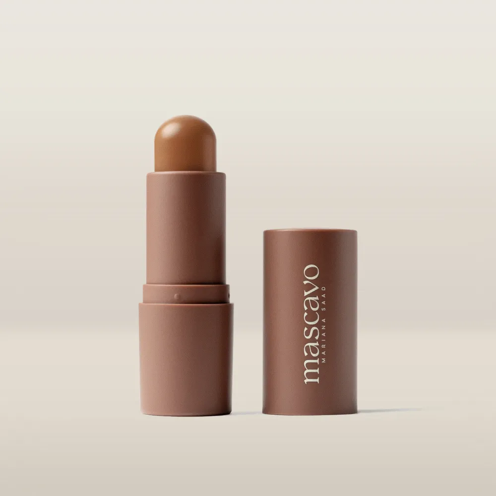 Bastão de maquilhagem castanho com tampa marrom e texto 'mascavo MARIANA SAAD'
