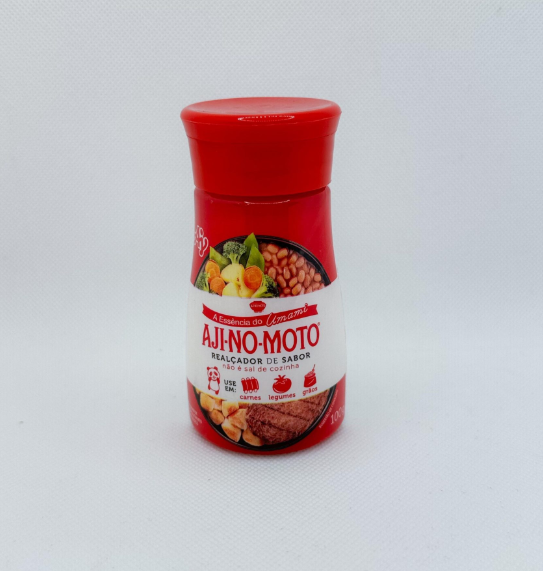 Frasco vermelho de AJI-NO-MOTO realçador de sabor numa superfície branca