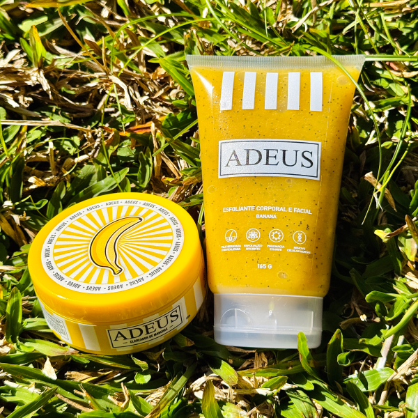 Produtos ADEUS de creme e esfoliante banana sobre relva.