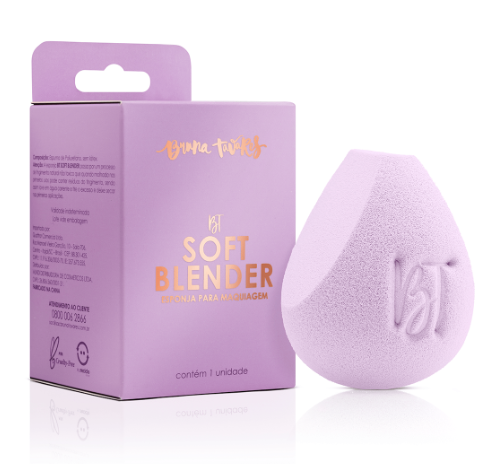 Esponja de maquilhagem lilás ao lado da caixa lilás com texto dourado e preto.