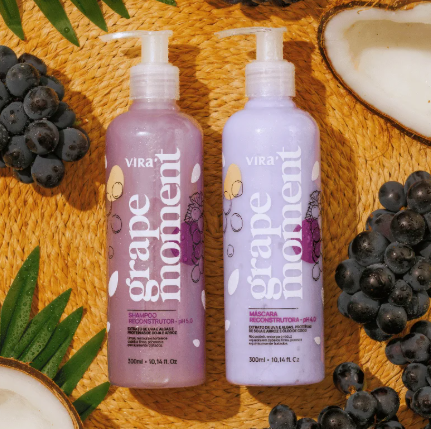 Dois frascos lilás de shampoo e máscara capilar Vira grape moment com uvas e coco ao redor