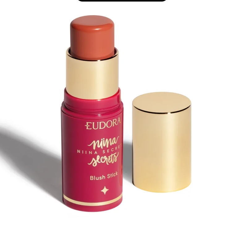 Blush stick cor salmão em embalagem vermelha com tampa dourada ao lado