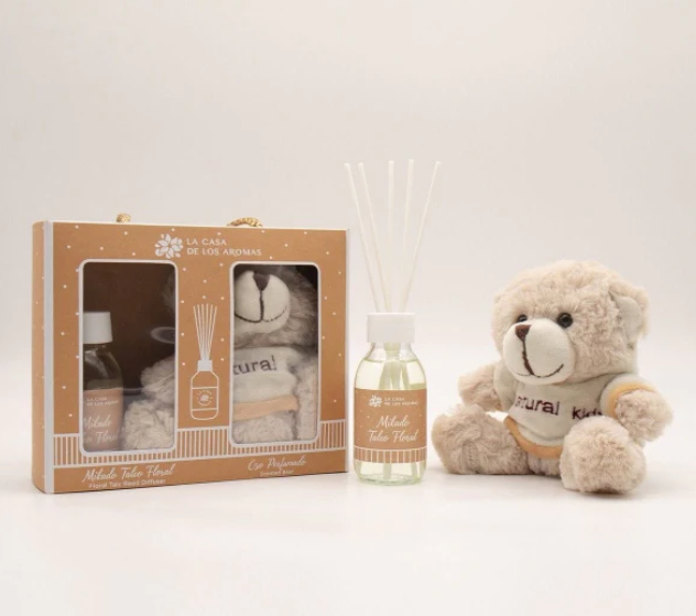 Conjunto de presente com difusor de aromas, toalha e urso de peluche.