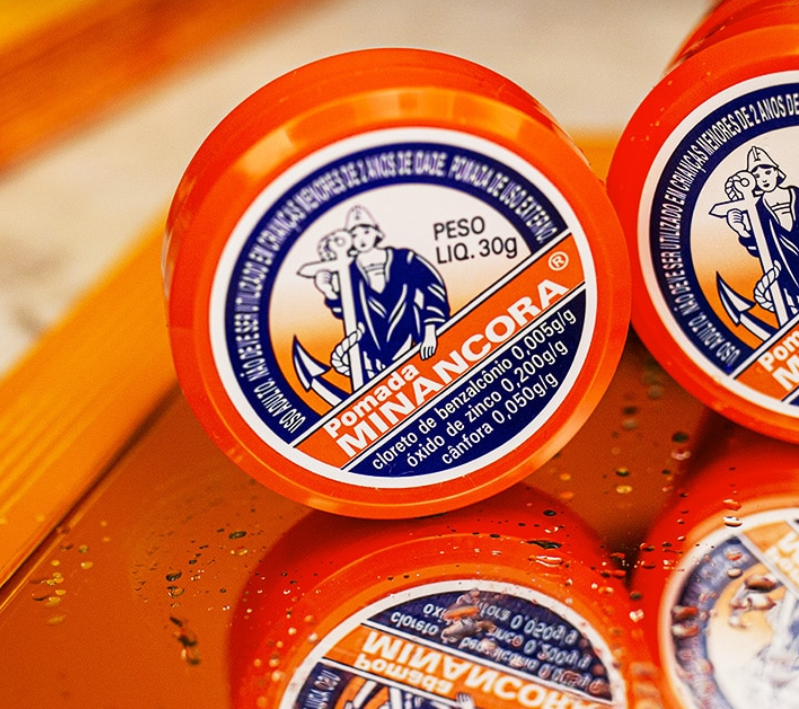 Frasco de pomada Mina Âncora com tampa laranja e etiqueta colorida
