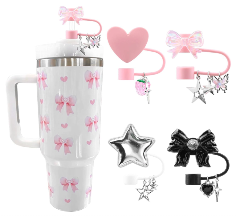 Copo de viagem branco com laços cor-de-rosa e tampa metálica, com quatro tampas coloridas e penduricalhos variados.