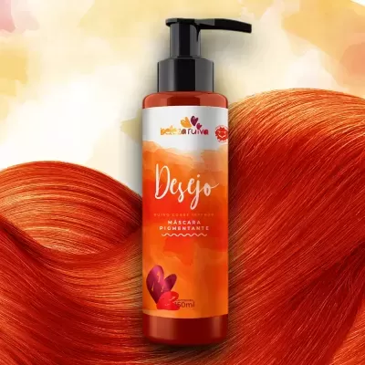 Frasco de máscara pigmentante laranja com rótulo colorido e cabelo laranja ao fundo.