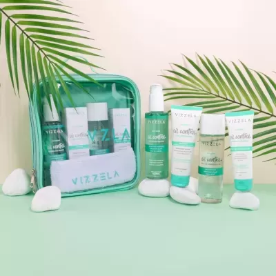 Conjunto de produtos de cuidados de pele Vizzela em saco transparente com folhas e pedras decorativas.