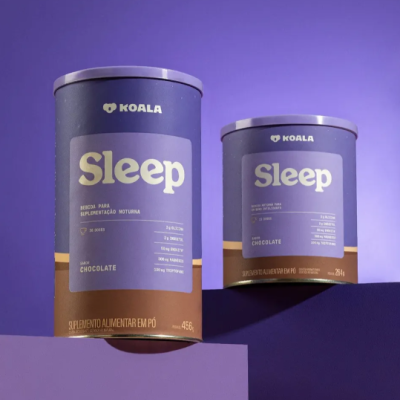 Dois recipientes cilíndricos do suplemento 'Sleep' da Koala, sabor chocolate, em fundo e superfícies roxas.