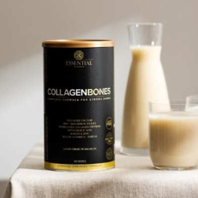 Suplemento collagen bones em embalagem preta dourada com copo e jarro de bebida clara numa mesa com toalha.