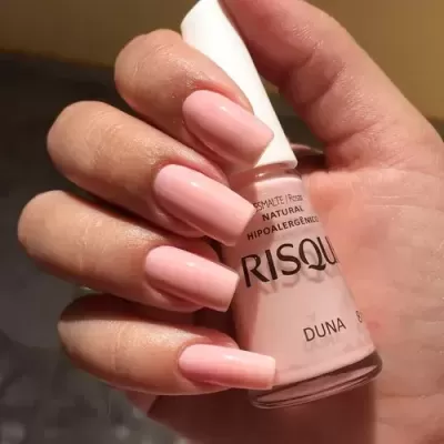 Verniz de unhas Risqué cor Duna em tom rosa claro com unhas pintadas