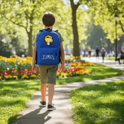 Criança de costas a usar mochila azul com lâmpada amarela e texto COLE ROSA num parque verde com flores.