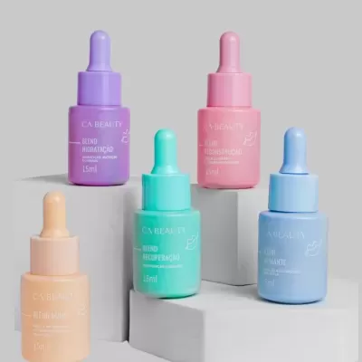 Cinco frascos coloridos de serum com conta-gotas sobre pedestais brancos.