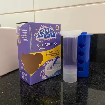 Gel adesivo lavanda Coala com aplicador e suporte azul sobre bancada preta