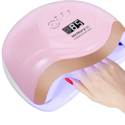 Lâmpada de gel para unhas cor de rosa com display digital e mão com unhas vermelhas