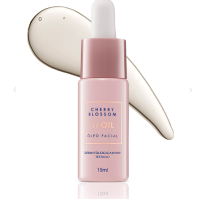 Frasco rosa de óleo facial Cherry Blossom com conta-gotas e mancha de óleo ao lado