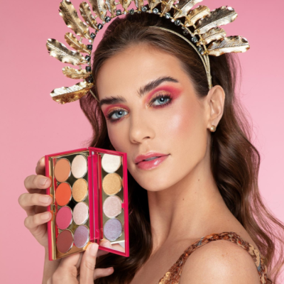 Mulher segurando paleta de sombras coloridas com coroa dourada