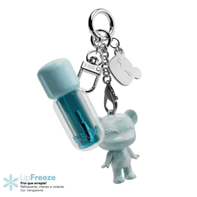 Porta-chaves com urso azul marmoreado, cápsula azul translúcida com texto M-BOOM e placa metálica com forma de urso