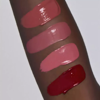 Braço com quatro faixas de batons em diferentes tons de rosa e vermelho